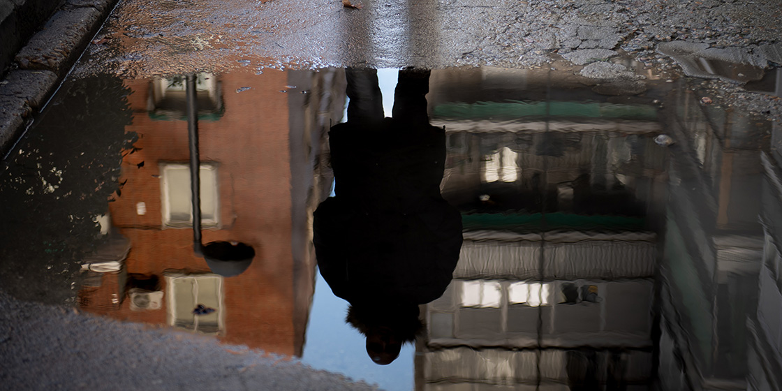 Reflejo en el agua de Yasim en la calle, a contraluz